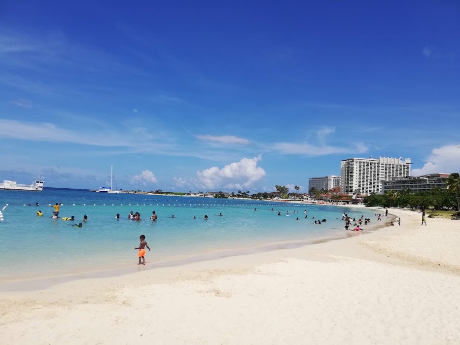 Ocho Rios Bay Beach with turquoise water, white sand and beachgoers enjoying the Caribbean Sea